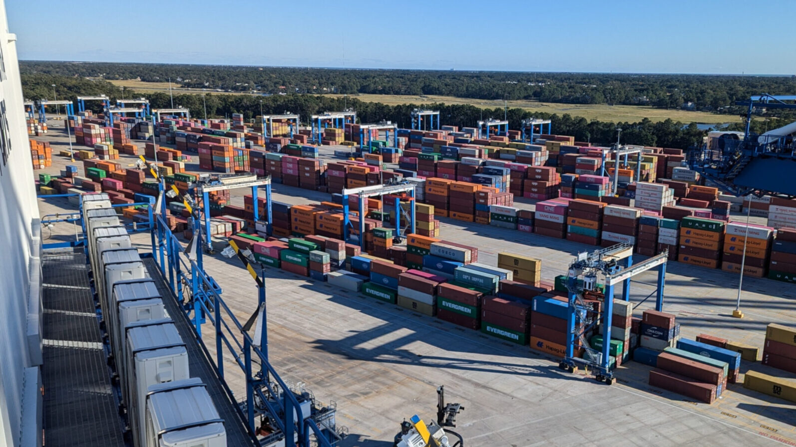 Drayage Yard full of shipping containers and cranes.